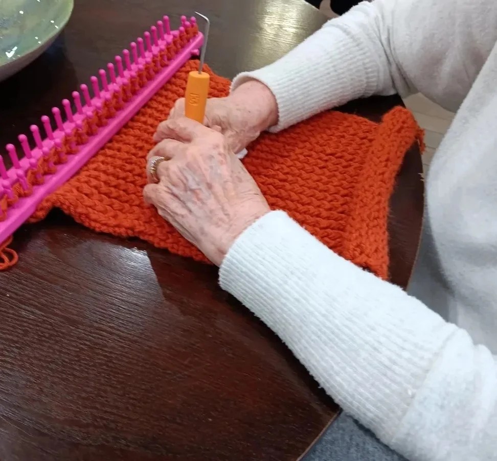 Senior learning how to loom knit